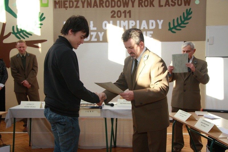 Nagrodę za udział w konkursie o lasach zorganizowanym w SP2 w Sycowie wręcza Pawłowi nadleśniczy Józef Szymański
