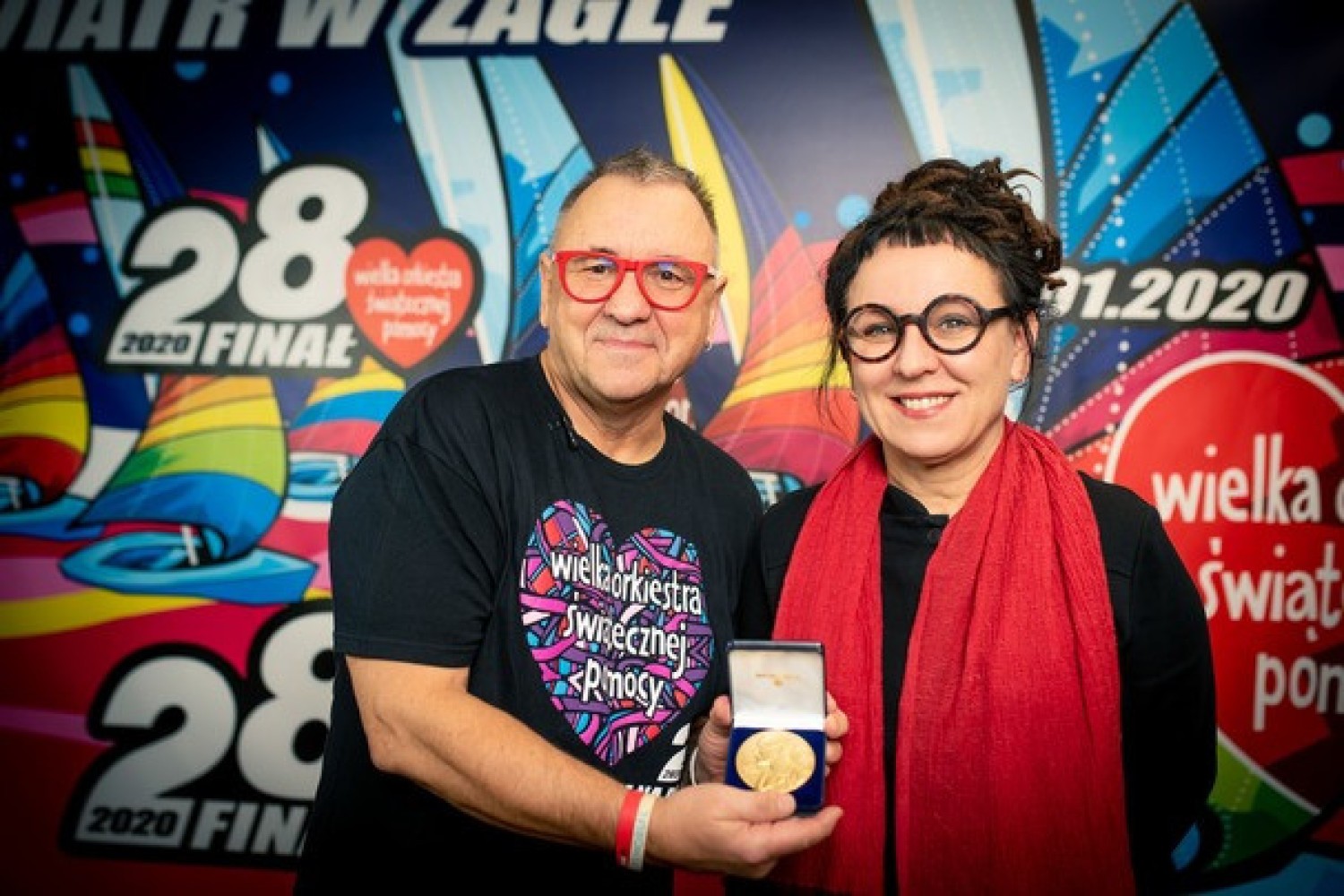 Olga Tokarczuk przekazuje replikę medalu noblowskiego Jurkowi Owsiakowi