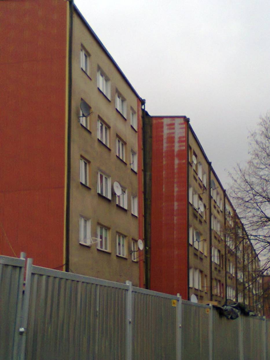 Widok na wyprostowaną klatkę bloku przy ulicy Joliot Curie 1j w dzielnicy Wirek