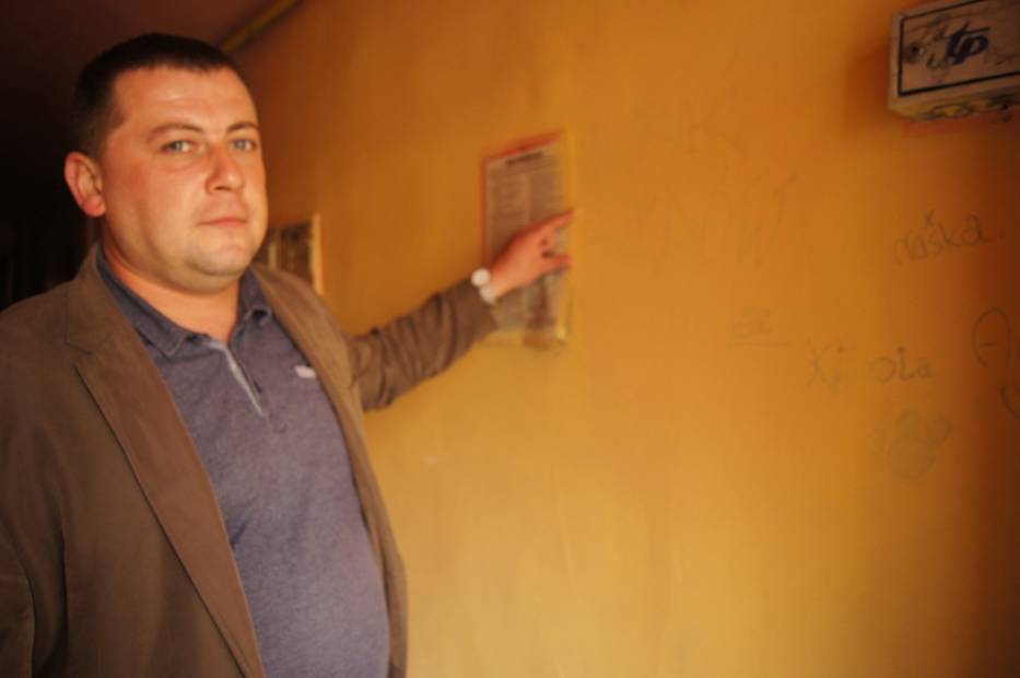 Tomasz Malec przy jednym z zamalowanych napisów antysemickich na ul